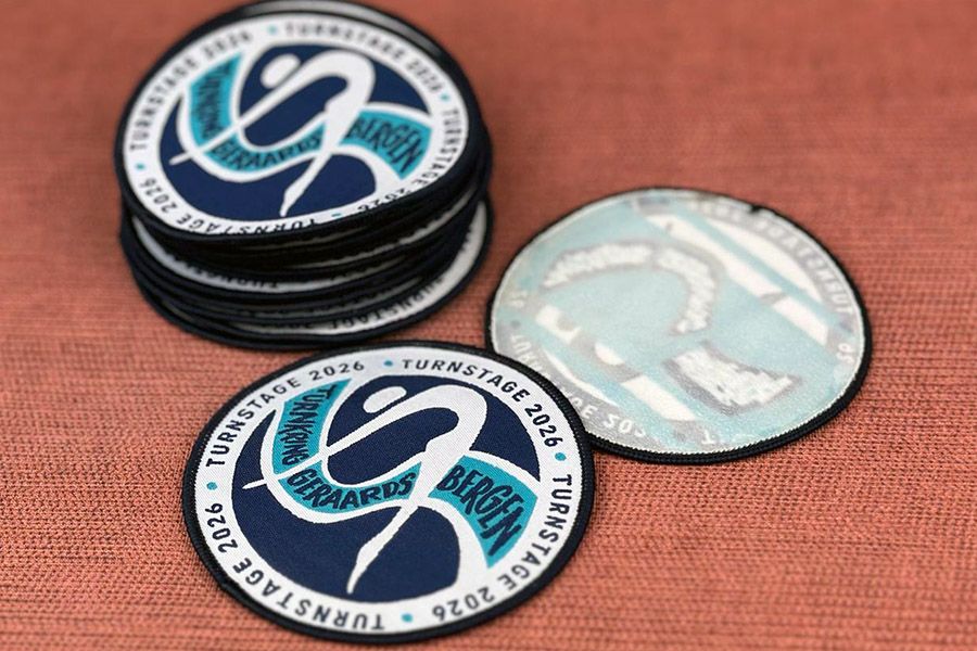ronde geweven patches met strijklaag achteraan voor Turnstage 2026 van Turnkring Geraardsbergen